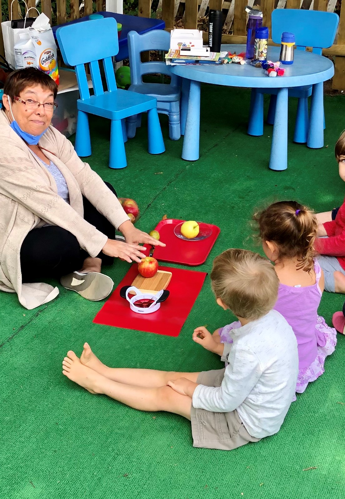 Women with children cutting apples